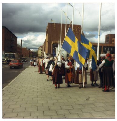 Parad med folkdräkter och svenska flaggor