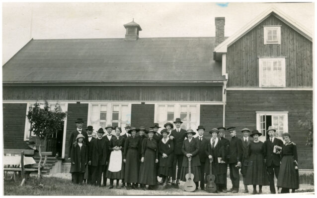 Gruppfoto utanför stort trähus.