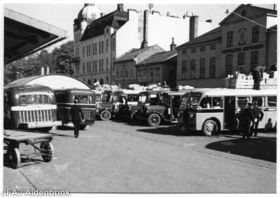 En samling bussar framför ett bryggeri.