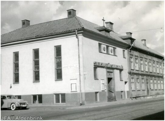 Ljus stenbyggnad i hörn.