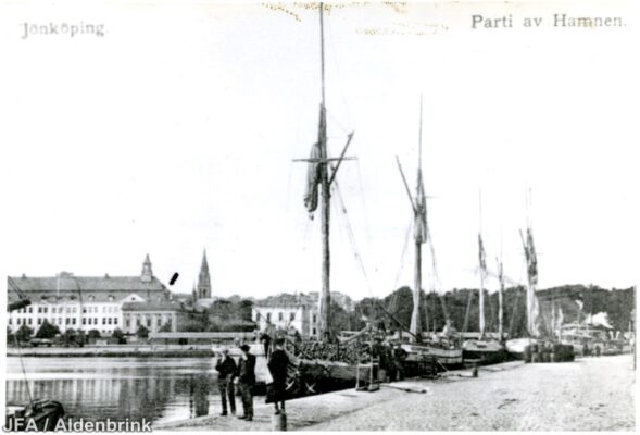Flera segelbåtar och människor i hamn.
