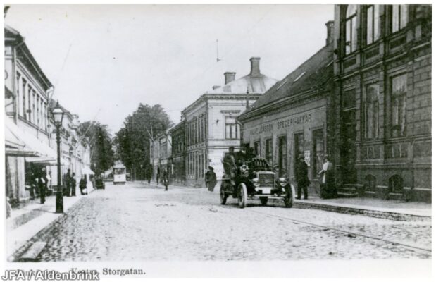 Västra storgatan med ålderdomlig bil och spårvagn.