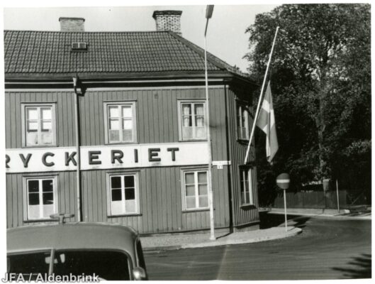 Ett tryckeri med flagga vid en korsning.
