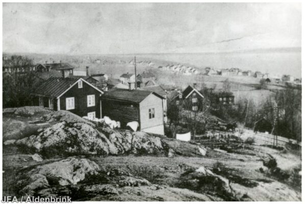 Några hus sedd från en klippig höjd.
