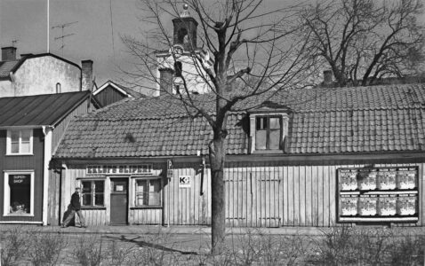 Trähus med Kristina kyrka i bakgrunden.