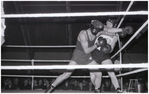 Två män i boxningsring boxas.