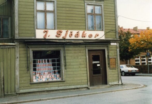 Grönt tvåvånings trähus med skylt "J Sjöåker"