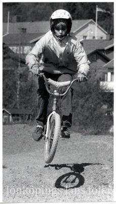 Pojke i hjälm gör ett hopp med sin cykel.