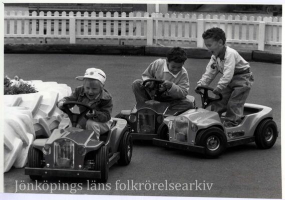 Småpojkar i små elektriska bilar. 