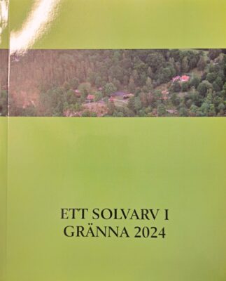 Grönt omslag med avlång bild av skog med lite bebyggelse på övre halvan och texten "Ett solvarv i Gränna 2024" på nedre.