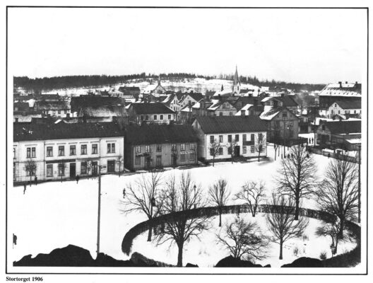 Vy över snötäckt stadstorg. 