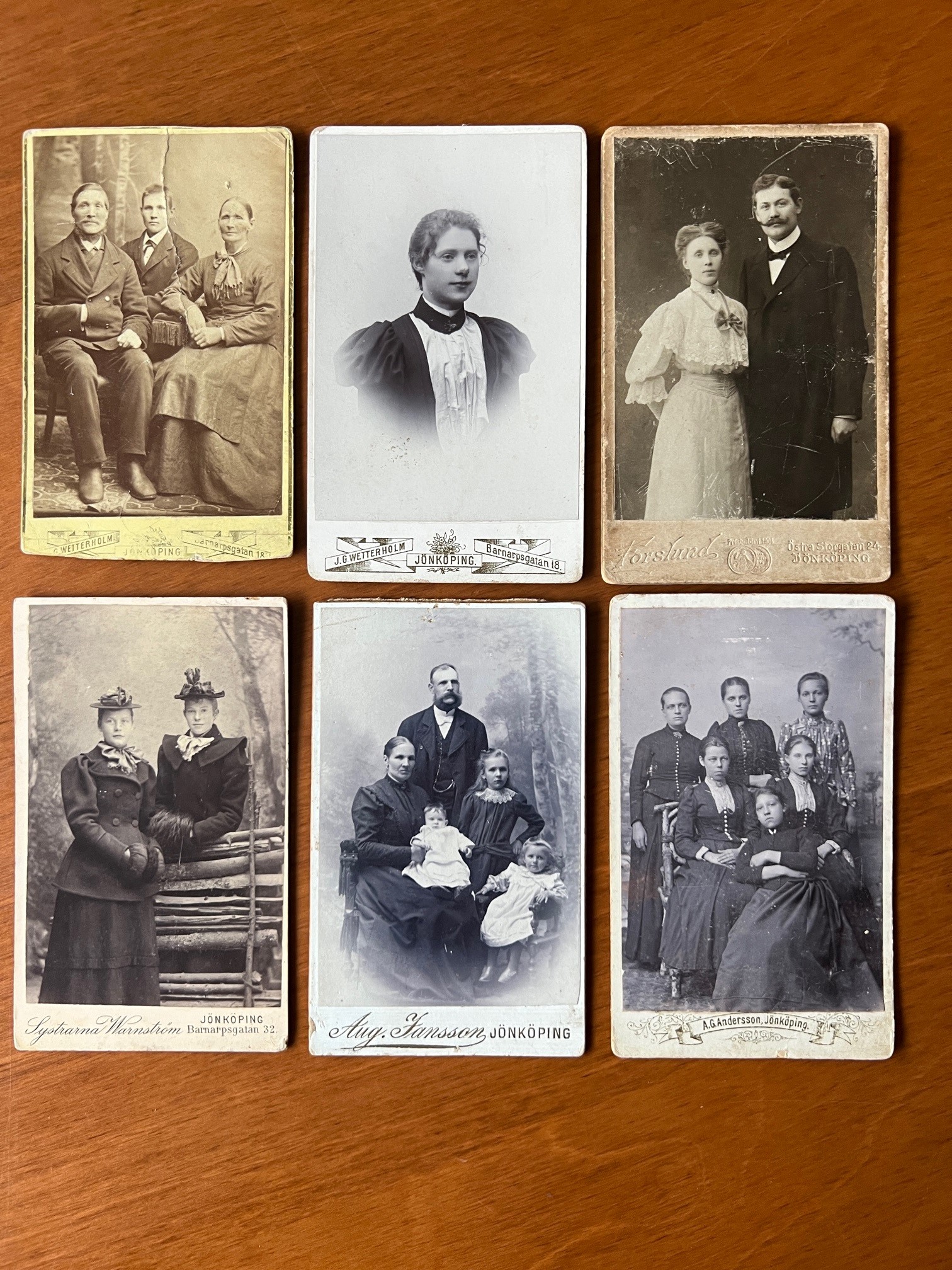 Sex stycken äldre porträtt/ateljéfotografier uppradade och avfotograferade mot ett träbord. 