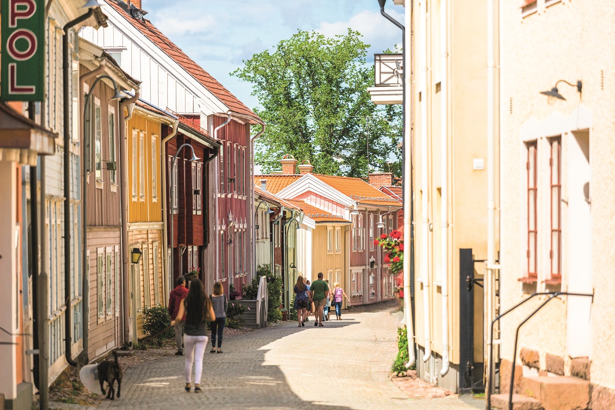 Gågata med trähus och några människor.