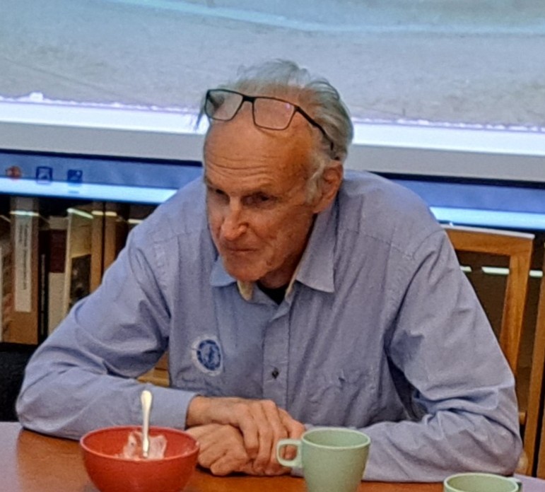 Man i blå skjorta till bords.