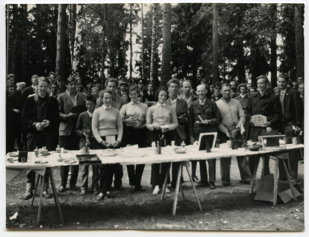 En större samling människor uppställda bakom ett bord.