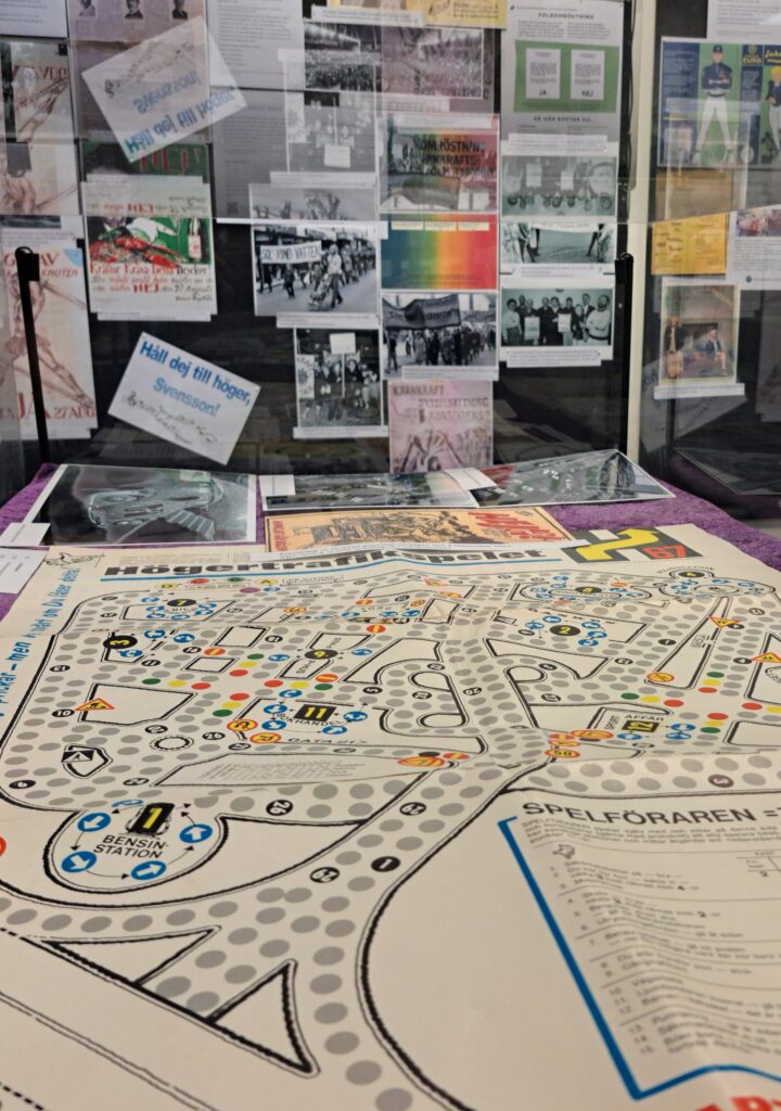 En del av utställningen i arkivhusets forskarsal, med ett spel i nederkant och en vägg med propaganda och texter där bakom.