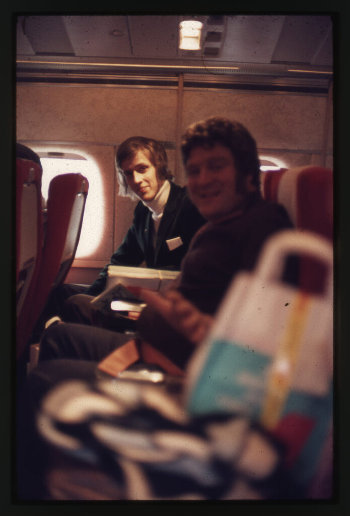 Två män sittande i ett flygplan.