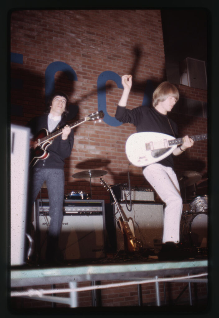 Två unga män på scen med elgitarrer.