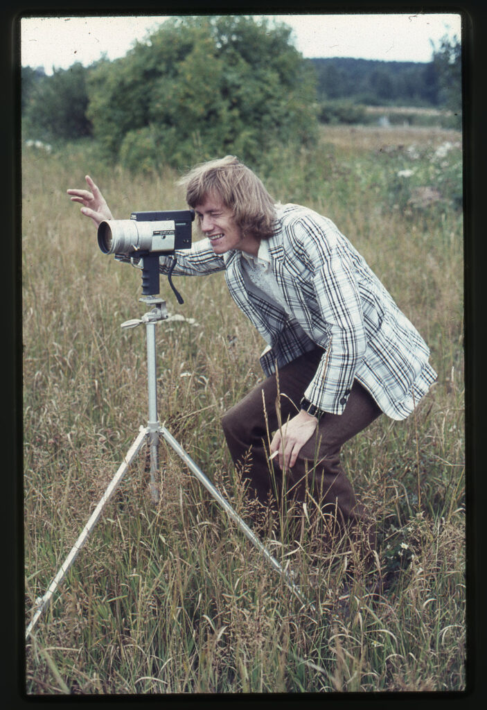 Man fotograferar med gammal kamera på ställning. 