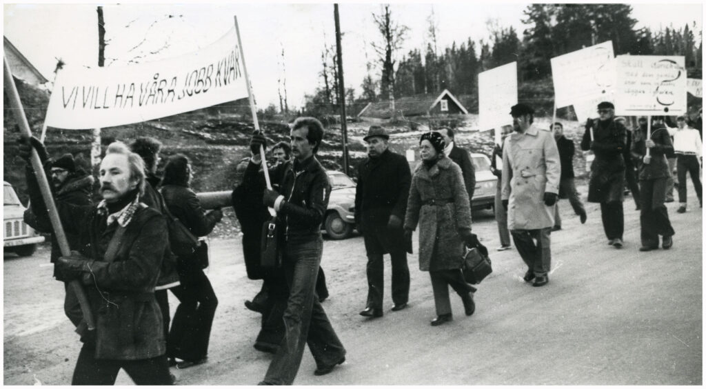 Ett demonstrationståg med bland annat texten "Vi vill ha våra jobb kvar".