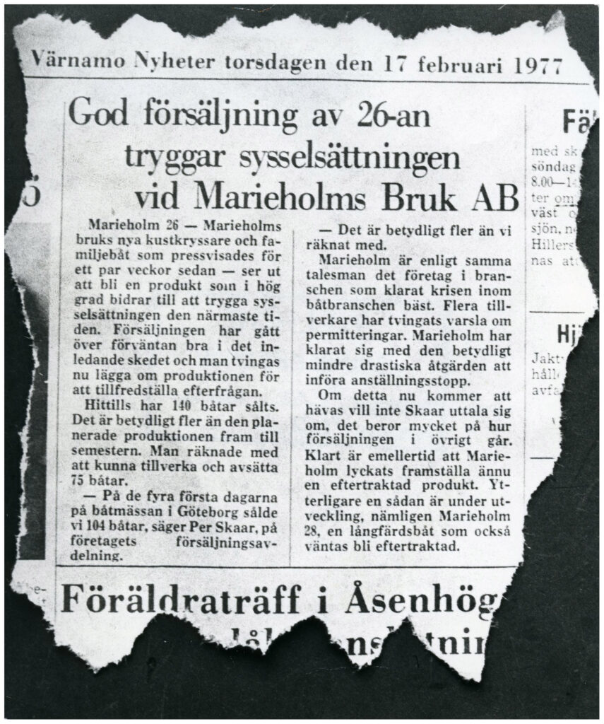 Tidningsartikel ur Värnamo Nyheter torsdagen den 17 februari 1977 med rubriken "God försäljning av 26-an tryggar sysselsättningen vid Marieholms Bruk AB" och innehållet "Marieholms 26 - Marieholms bruks nya kustkryssare och familjebåt som pressvisades för ett par veckor sedan - och ser ut att bli en produkt som i hög grad bidrar till att trygga sysselsättningen den närmaste tiden. Försäljningen har gått över förväntan bra i det inledande skedet och man tvingas nu lägga om produktionen för att tillfredsställa efterfrågan. Hittills har 140 båtar sålts. Det är betydligt fler än den planerade produktionen fram till semestern. Man räknade med att kunna tillverka och avsätta 75 båtar. - På de fyra första dagarna på båtmässan i Göteborg sålde vi 104 båtar, säger Per Skaar, på företagets försäljningsavdelning. - Det är betydligt fler än vi räknat med. Marieholm är enligt samma talesman det företag i branschen som klarat krisen inom båtbranschen bäst. Flera tillverkare har tvingats varsla om permitteringar. Marieholm har klarat sig med den betydligt mindre drastiska åtgärden att införa anställningsstopp. Om detta nu kommer att hävas vill inte Skaar uttala sig om, det beror mycket på hur försäljningen i övrigt går. Klart är emellertid att Marieholm lyckats framställa ännu en eftertraktad produkt. Ytterligare en sådan är under utveckling, nämligen Marieholm 28, en långfärdsbåt som också väntas bli eftertraktad.