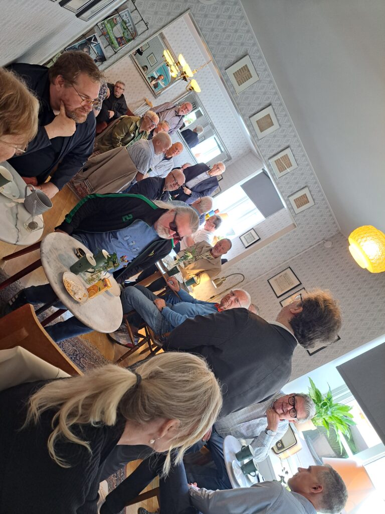 Stor grupp människor i café.