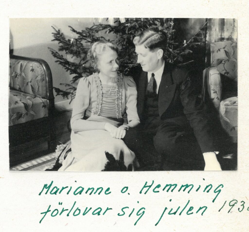 Ett par sitter framför en julgran.